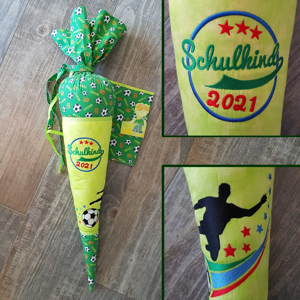 Schultüte aus Stoff im Fußballdesign. Die Tüte besteht aus einem grünen Stoff mit Fußballmotiven und einer gelb-grünen Vorderseite. In der Mitte der Schultüte ist der Schriftzug "Schulkind 2021" in bunten Farben gestickt, umgeben von drei riten Sternen oben.Weiter unten ist ein Fußballer in Schwarz gestickt, der zum Ball tritt. Umgeben von Sternen und Geschwungenen Linien in Grüß, blau und rot. Die Schultüte ist mit einem Band verschlossen, passend zum Stoff der Schultüte. Daneben ist ein Umschlag für ein Hausaufgabenheft zu sehen, die im gleichen Fußball-Design genäht ist.