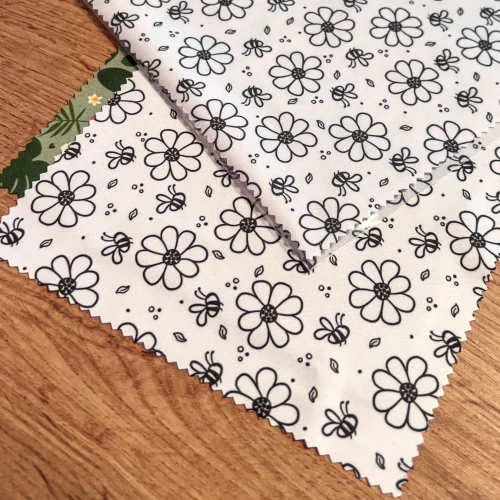 Micrfofastertücher für Brillen und Displays, hier mit Muster Bienen und Blumen. Es liegen 3 Tücher übereinander. Ein weiteres Grünes Tuch liegt als unterstes (Dschungelblumen)