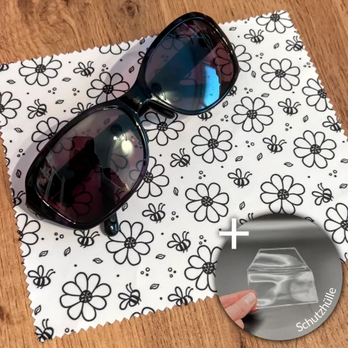 Brillenputztuch mit sßen Bienen und Blumen in schwarz-weiß, als Deko liegt eine Sonnenbrille auf dem Tuch. Am rechten unteren Eckenrand ist ein Bild einer Schutzhülle passend für das Tuch