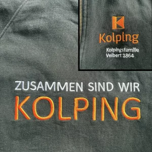 Logostickerei: Hauptbild Rückenstick auf schwarzem Hoodie "Zusammen sind wir Kolping", Das Wort Kolping ist mit orangenem Stickgarn gestickt. Die restlichen Wörter schweben darüber und sind in weiß gestickt. Rechts oben ist noch eine Detailaufnahme vom Bruststick: Logo der Kolpingsfamilie Velbert